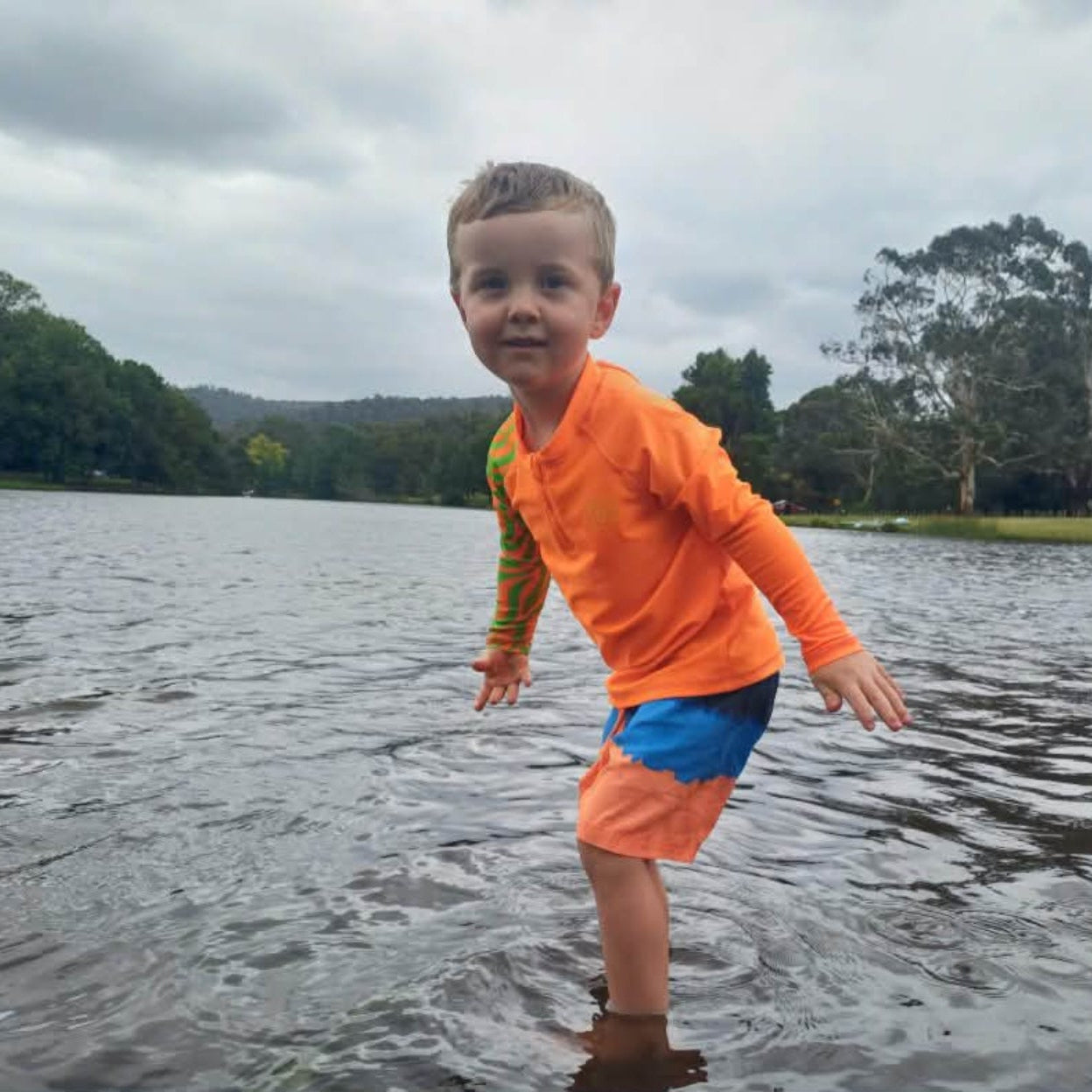 Child wearing bright Orange Sea Me Swimwear Zebra Rash Top
at the Lake.